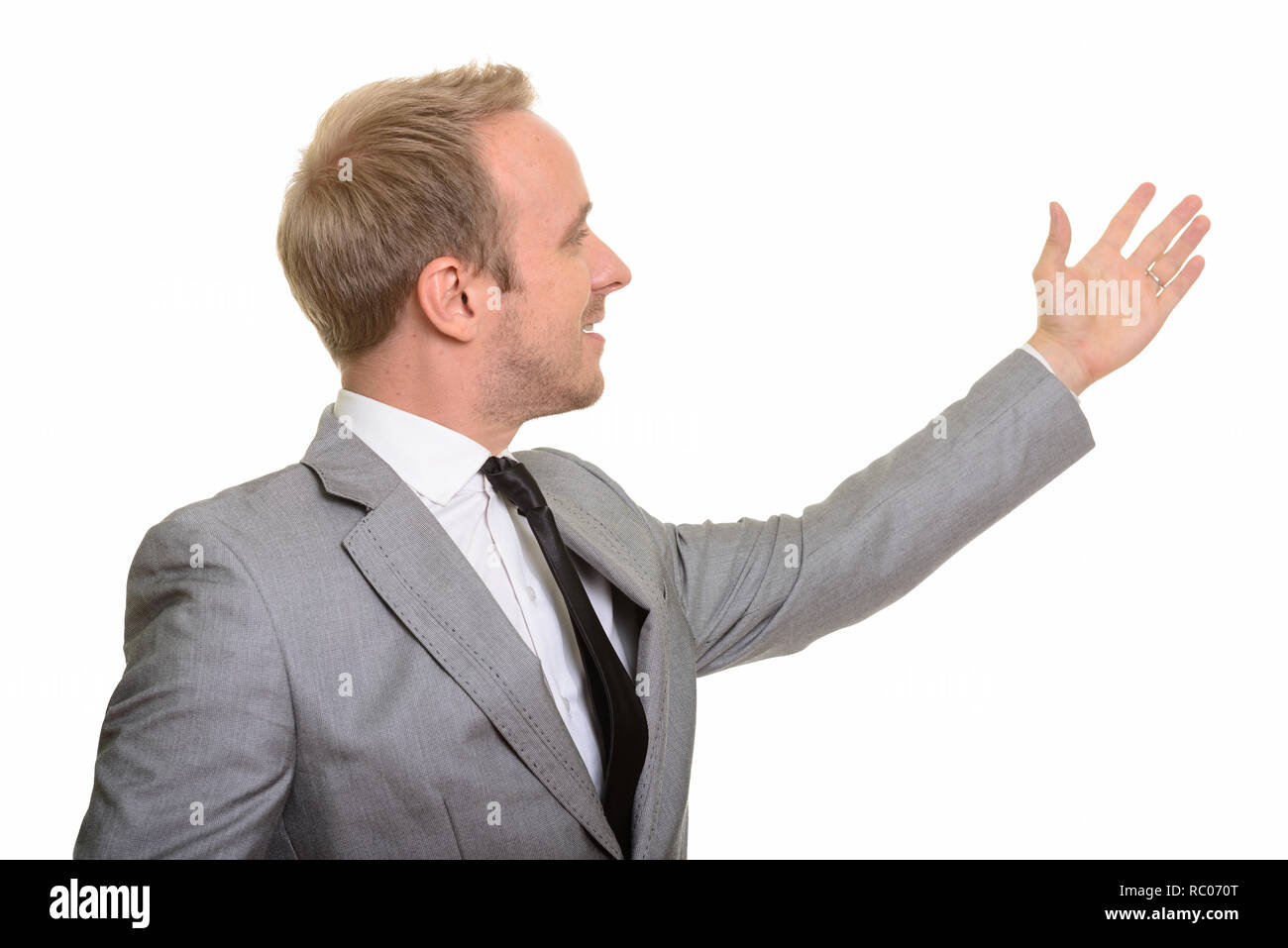 Profile view of handsome Caucasian businessman showing something Stock Photo