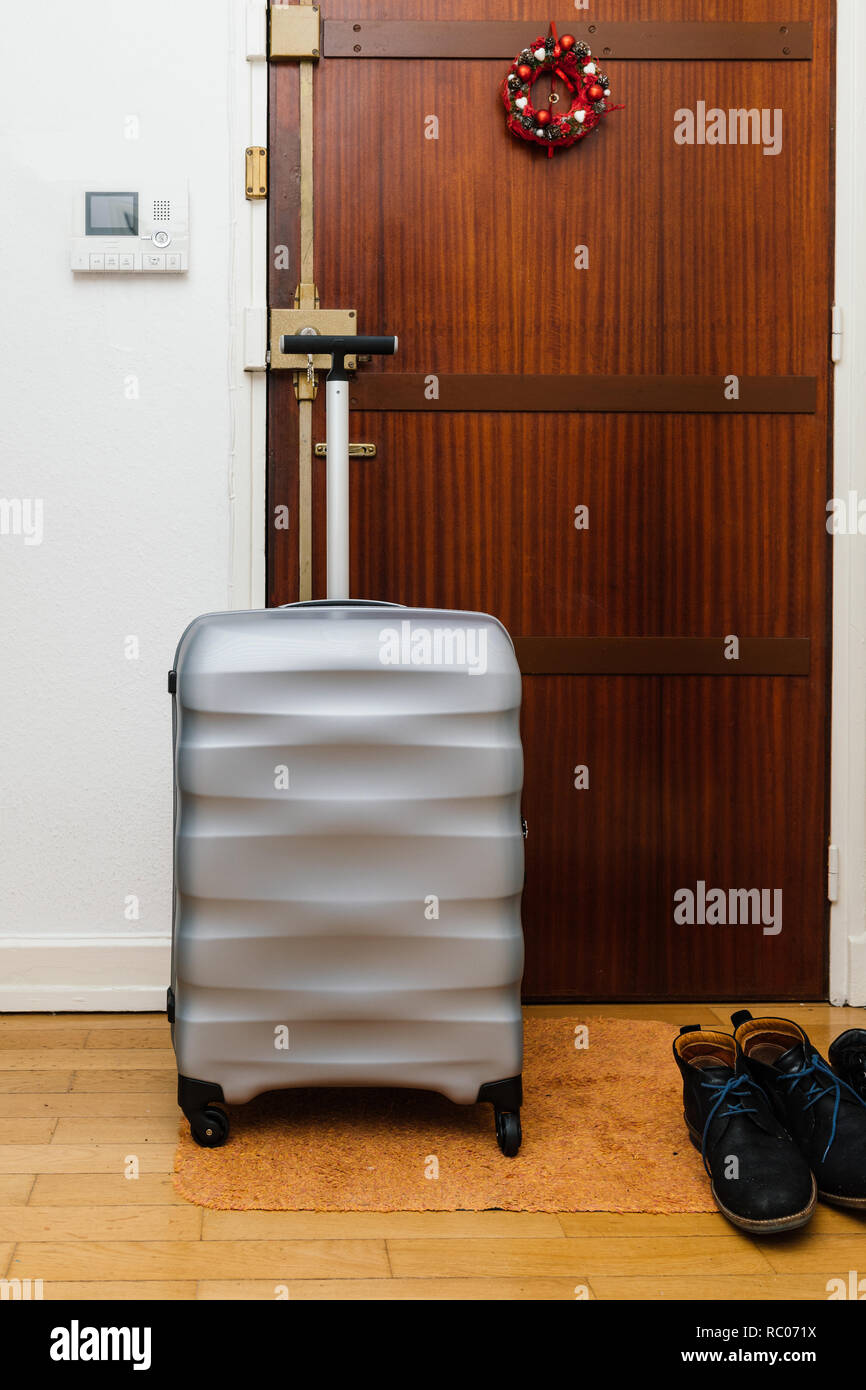 Travel suitcase briefcase luggage in front of the wooden door before