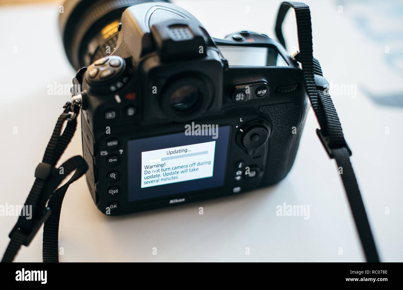 PARIS, FRANCE - JAN 31, 2018: Nikon DSLR Camera Professional updating firmware with message on the screen: Do not turn camera off during update Stock Photo