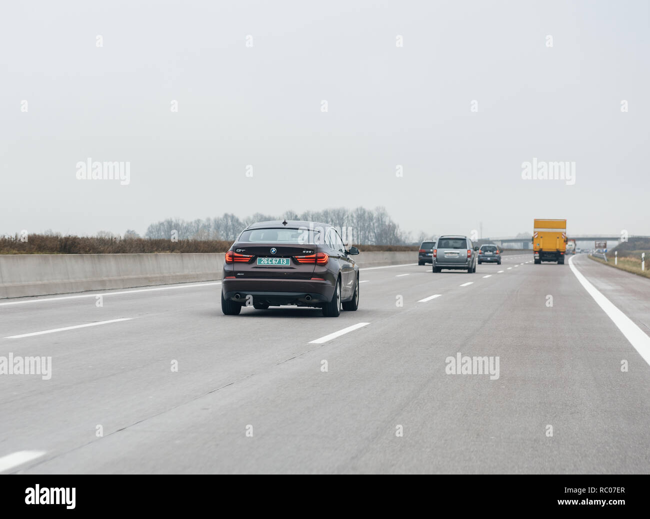FRANKFURT, GERMANY - FEB 18, 2018: Driver POV personal perspective toward the driving BMW 535i GT luxury purple red car on the autobahn highway  Stock Photo