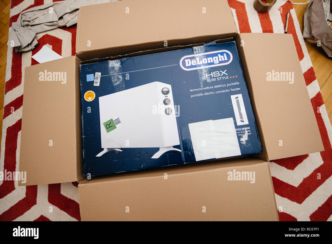 PARIS, FRANCE - FEB 7, 2018: Unboxing large cardboard box containing italian DeLonghi air convection heater bought from Amazon Warehouse Deals Stock Photo
