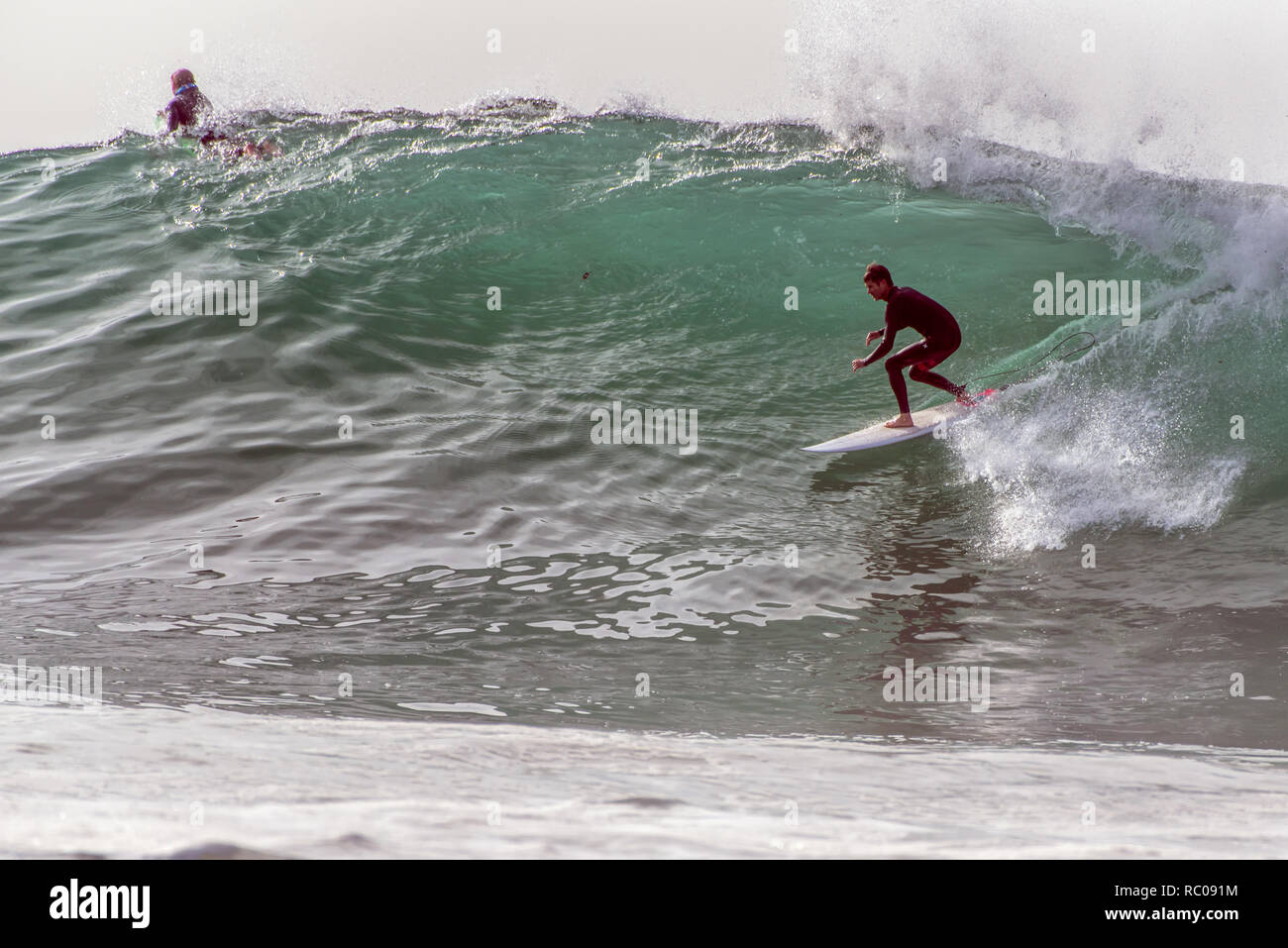Regular foot surfer in black wetsuit dropping in going right on large