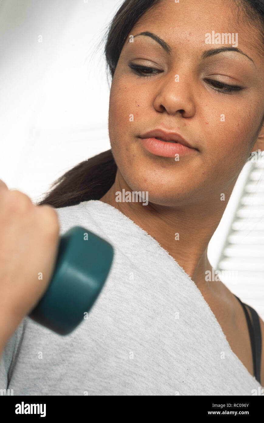 Young female adult lifting weights, USA Stock Photo