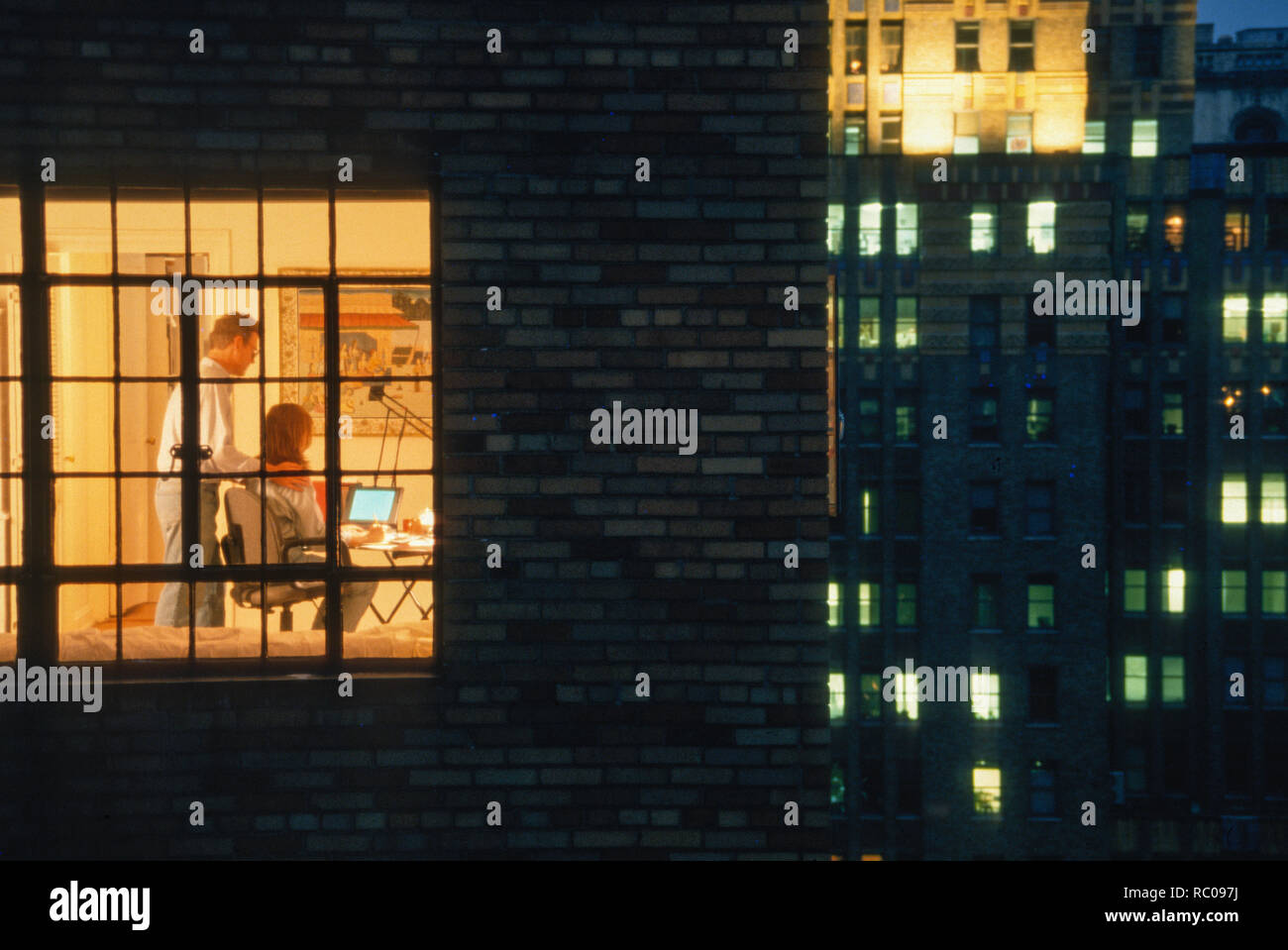 Couple Working late in high-rise apartment Home Office, NYC, USA Stock Photo