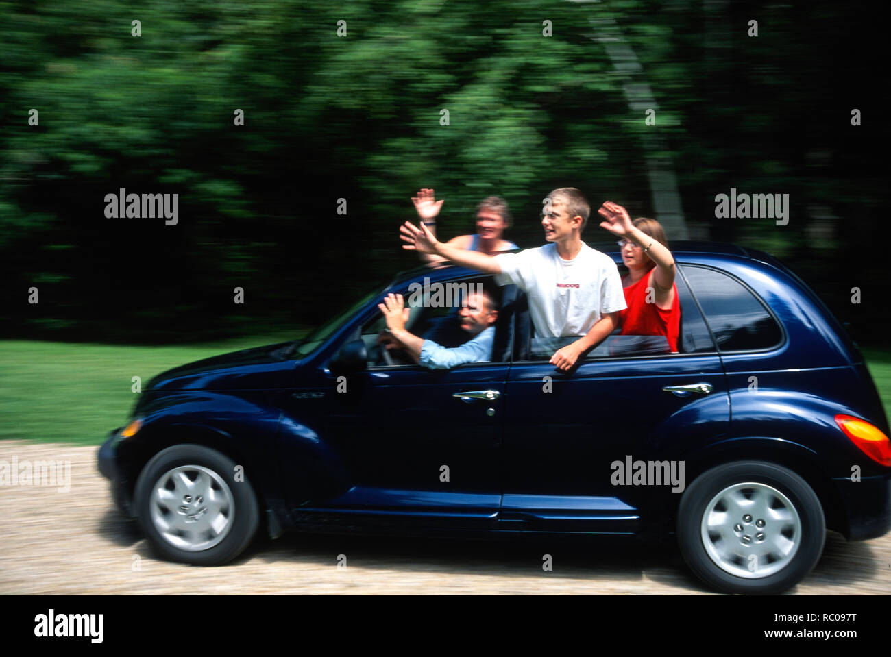 Family waving while driving in car, motion blur, USA Stock Photo