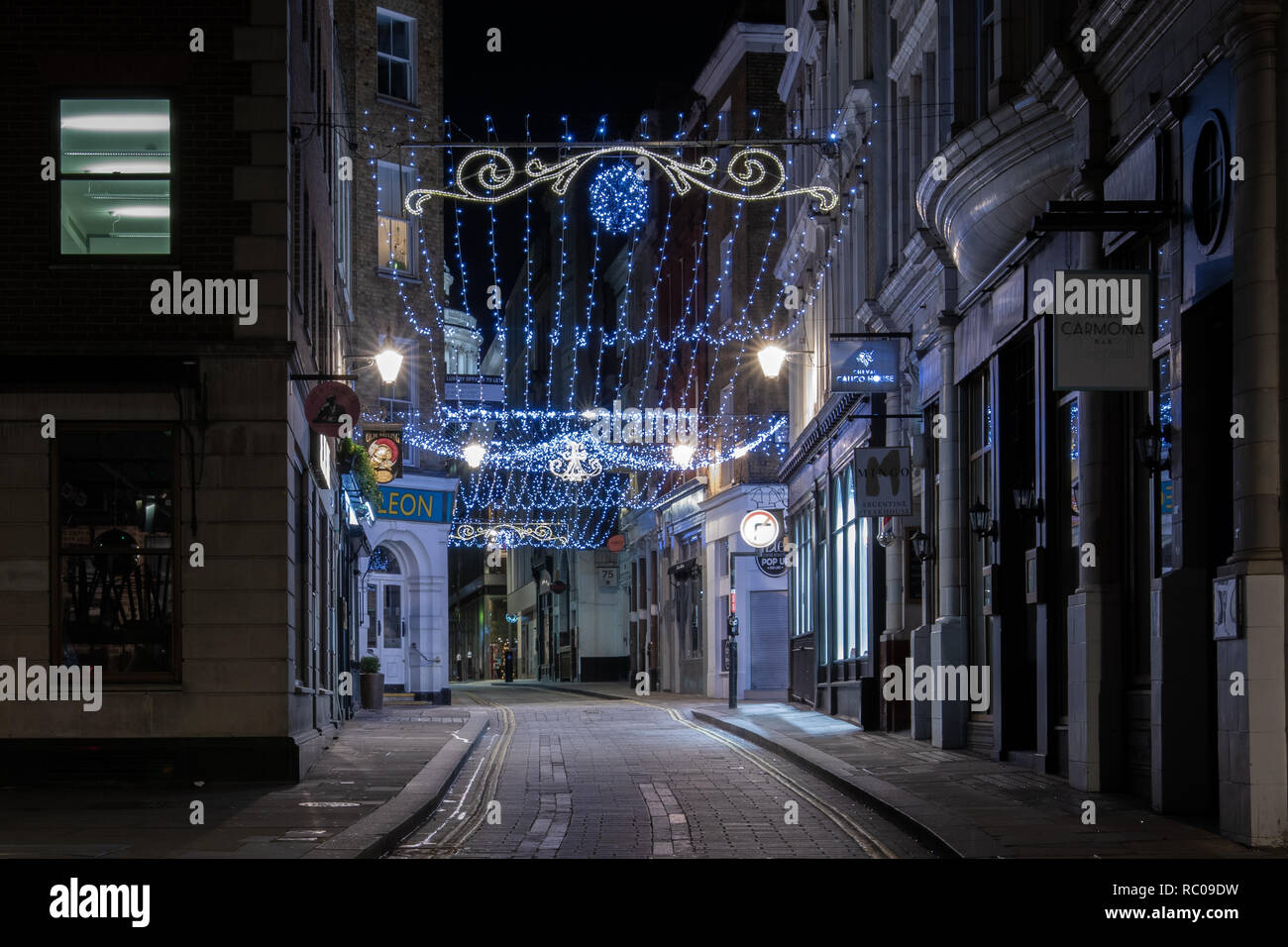 Empty night street in London with Christmas Lights and streetlights. Empty street in after Christmass London night. Stock Photo