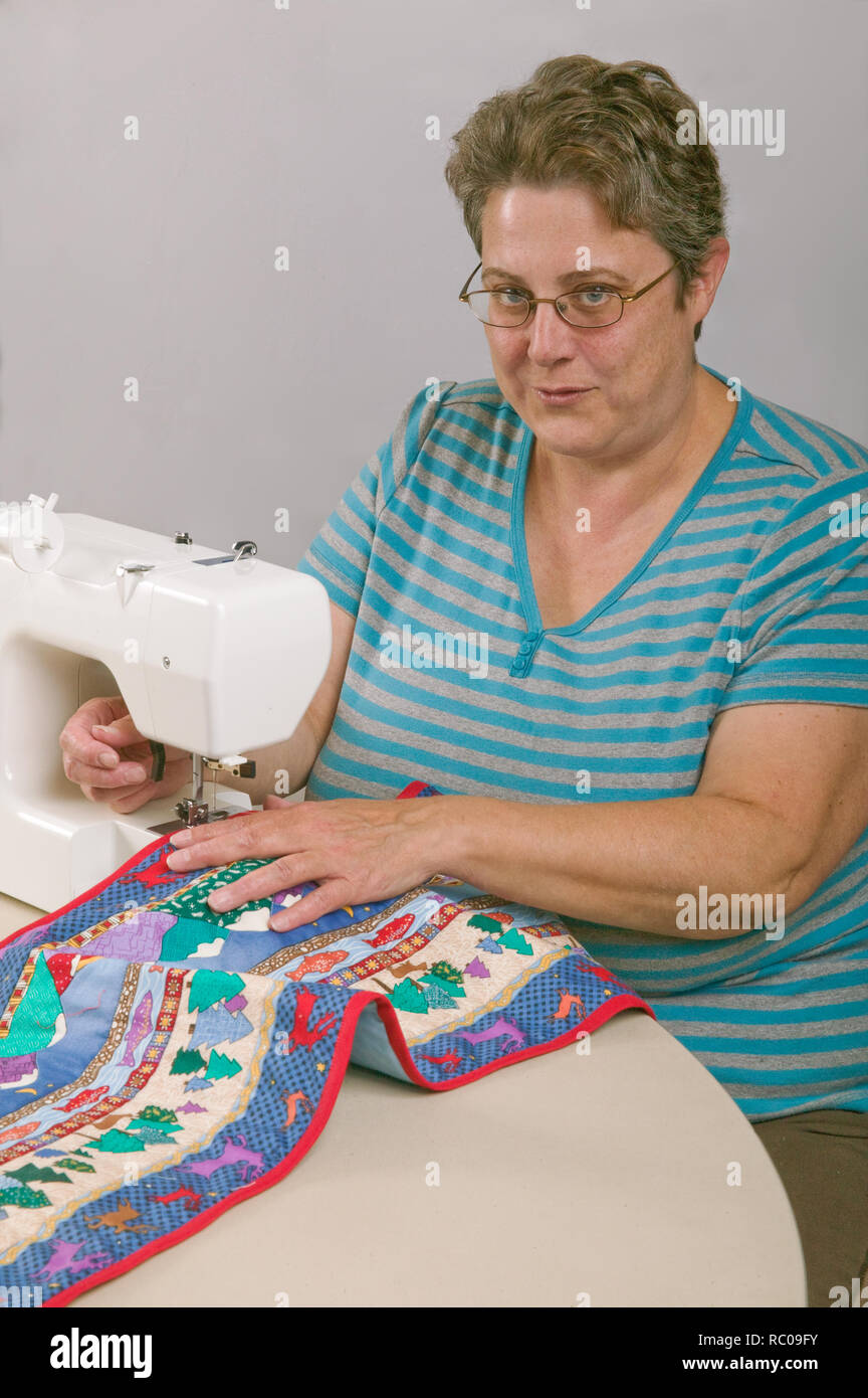 Woman piecing a quilt on a sewing machine. (MR Stock Photo Alamy