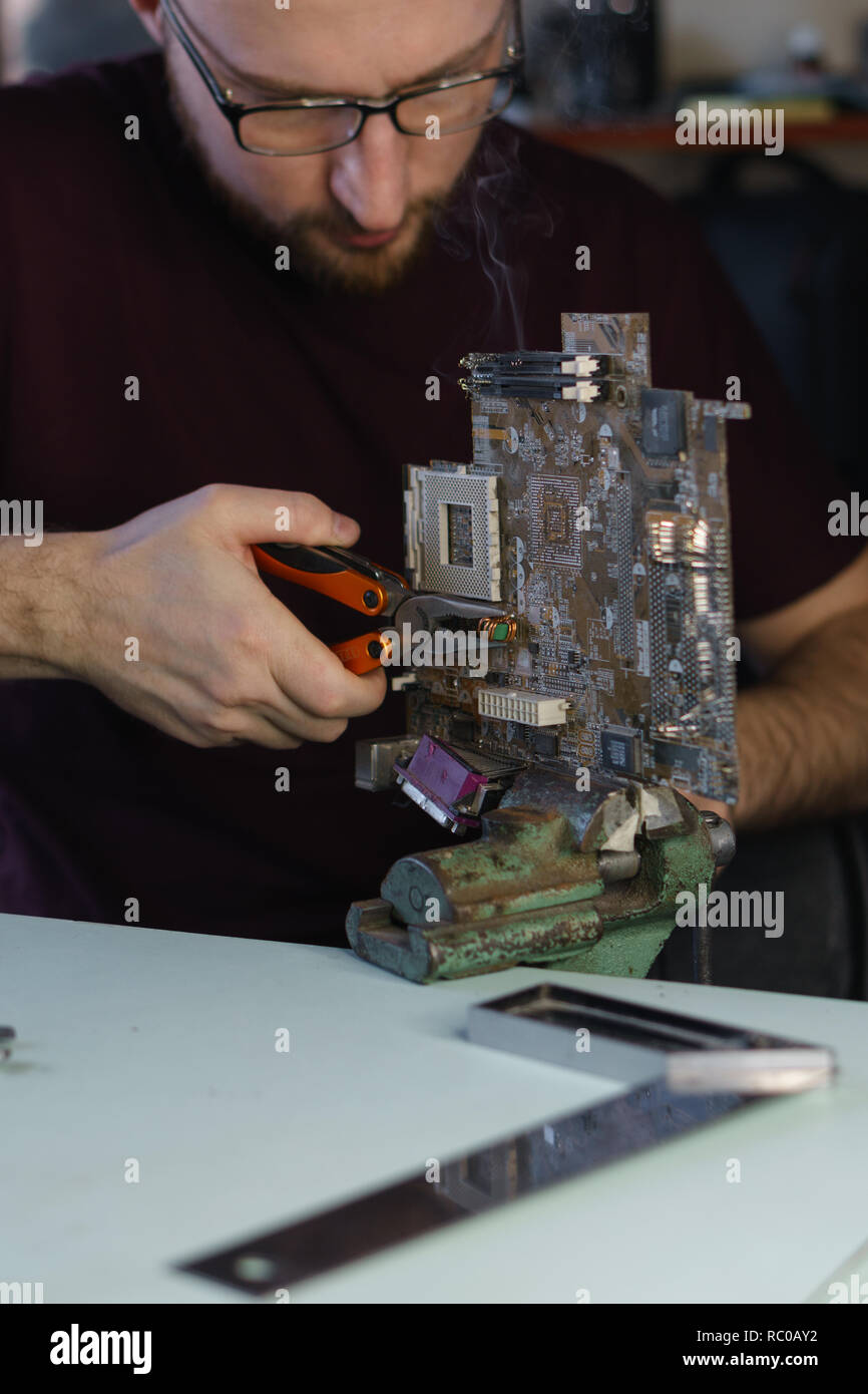 Repair motherboard. Service technician changes capacitor ...