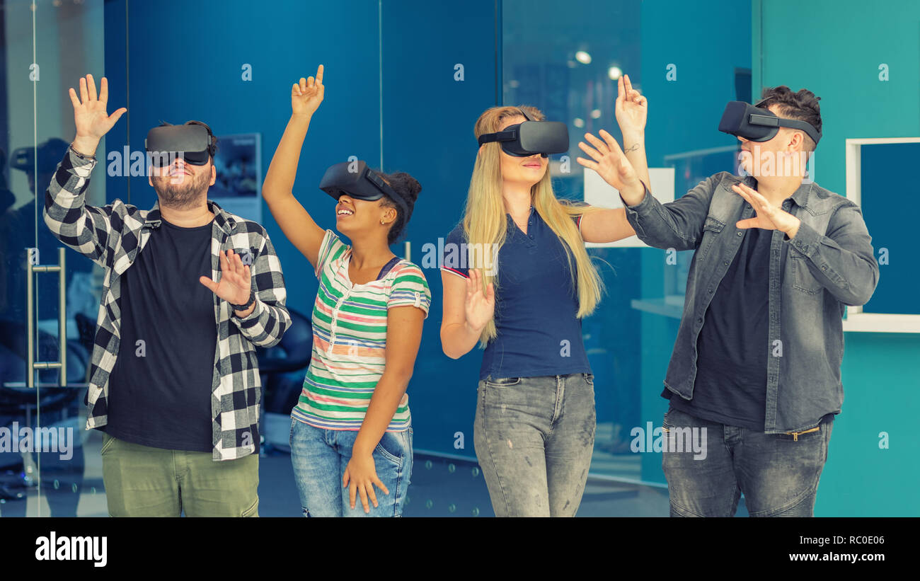Multiracial friends group playing on vr glasses indoors - Virtual reality and wearable tech concept with young people having fun together connecting w Stock Photo