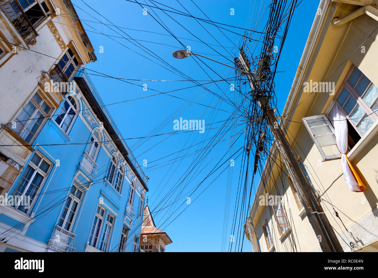 A seemingly tangled and disorganised collection of overhead cables in a street in Valparaiso, Chile. Stock Photo