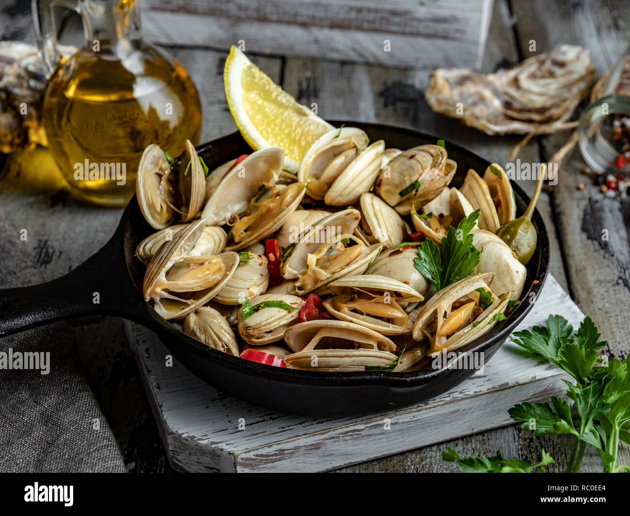 Cooked seafood steamed clams in the iron pan portion with lemon and