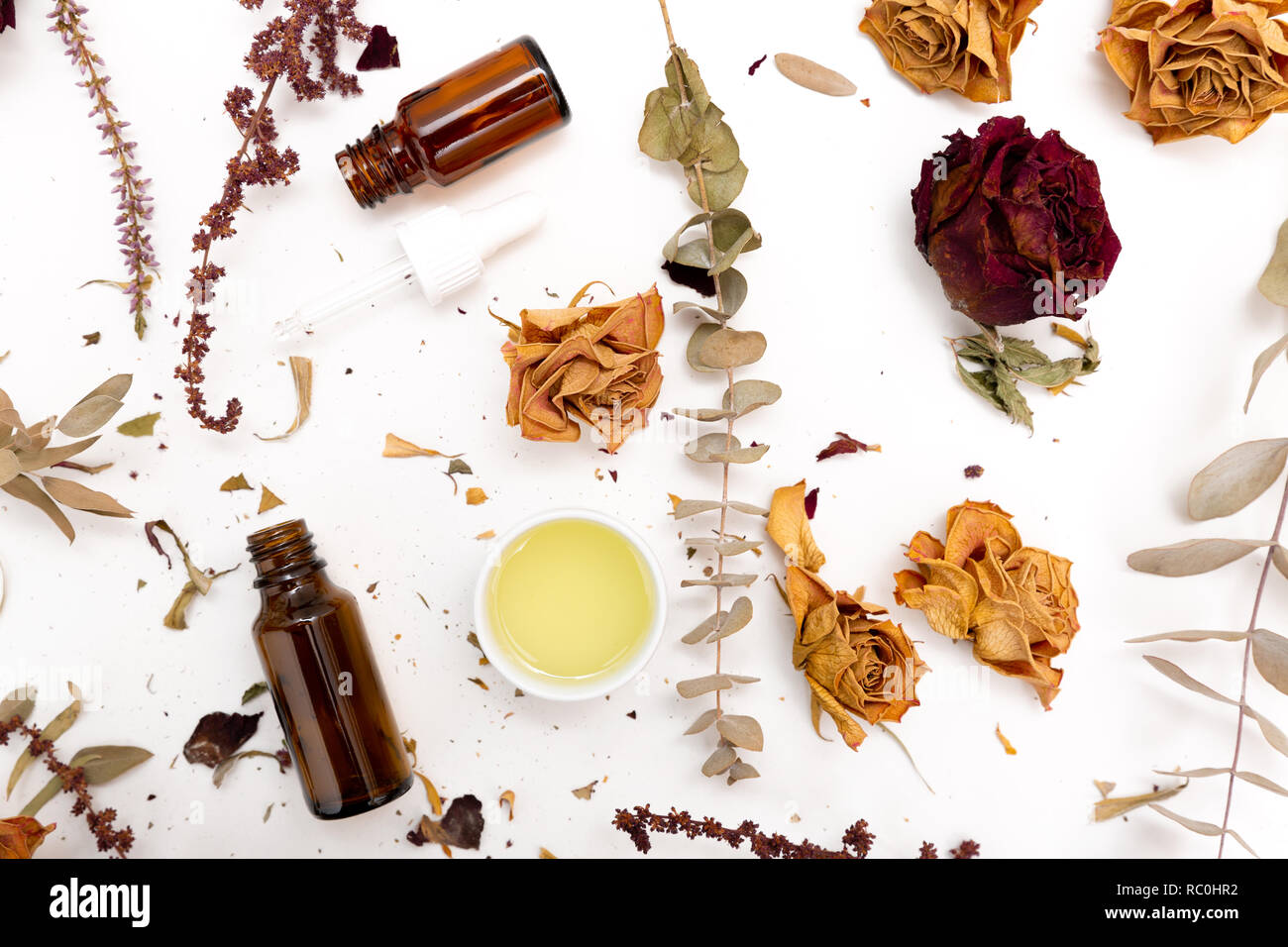 Aromatic botanical cosmetics. Dried herbs flowers mixture, facial mud clay mask, oils, applying brush. Holistic herbal skincare beauty hack Stock Photo