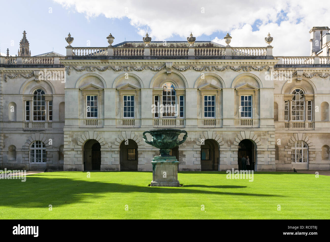 Exterior front courtyard of Kings College university Chapel with statue on well kept lawn, Cambridge, UK Stock Photo