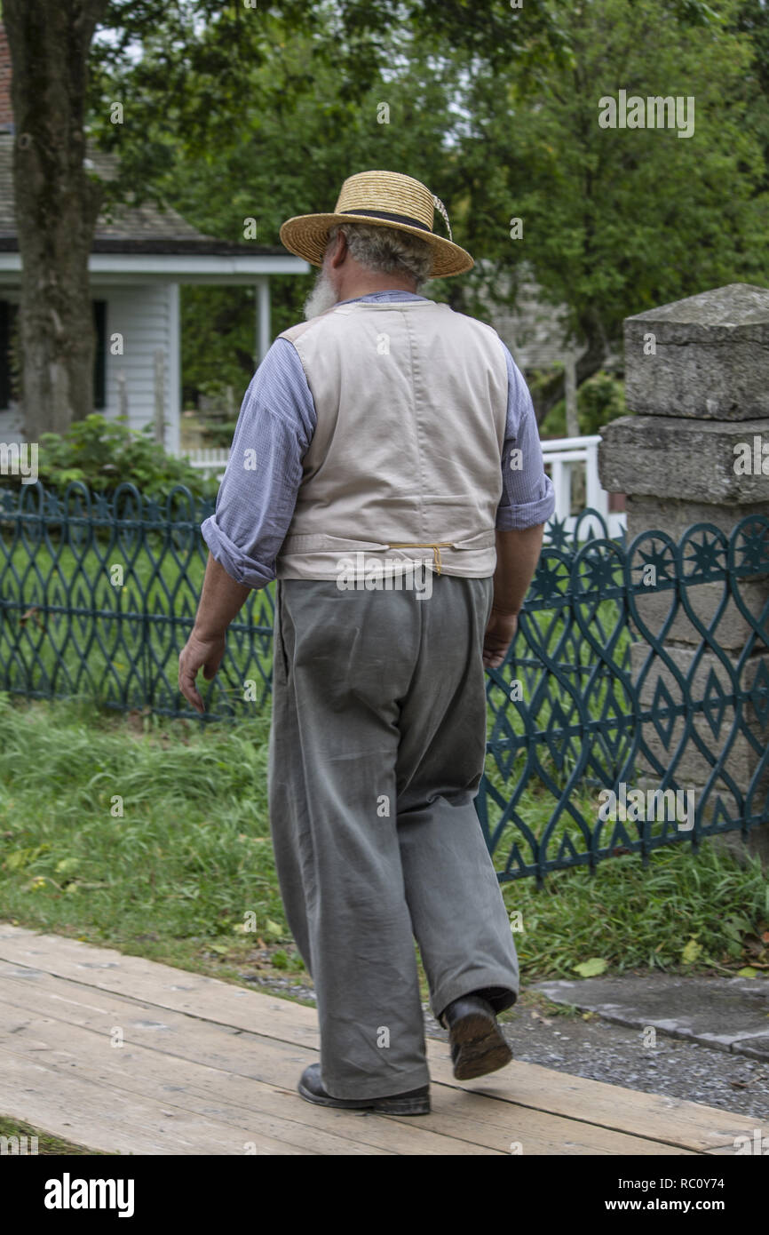 A walking along the street dressed in an ancient clothes in Upper Canada village Stock Photo
