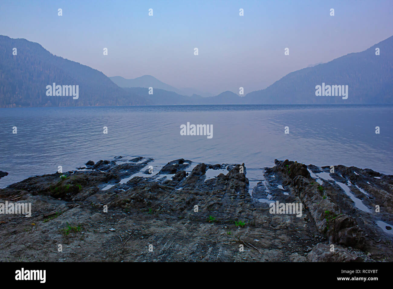 twilight settles over lake with volcanic rocky shoreline in washington state Stock Photo