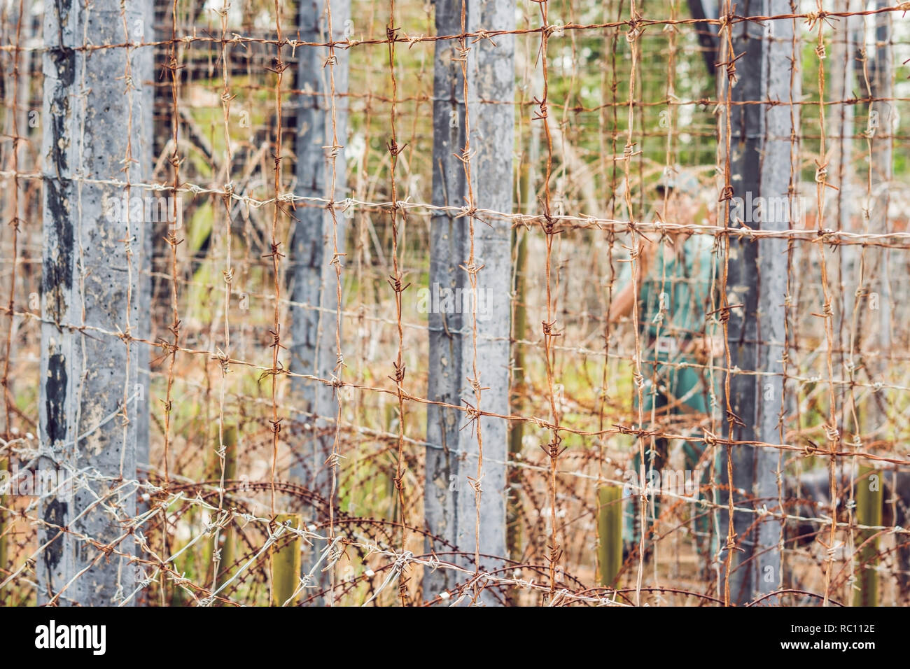Barbed wire, a fence in prison and the silhouette of a prison guard on