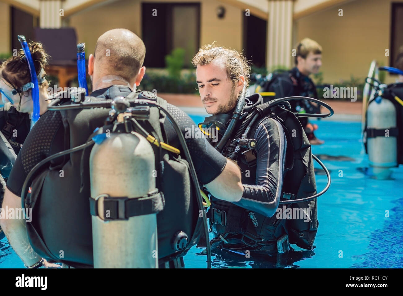 Diving instructor and students. Instructor teaches students to dive