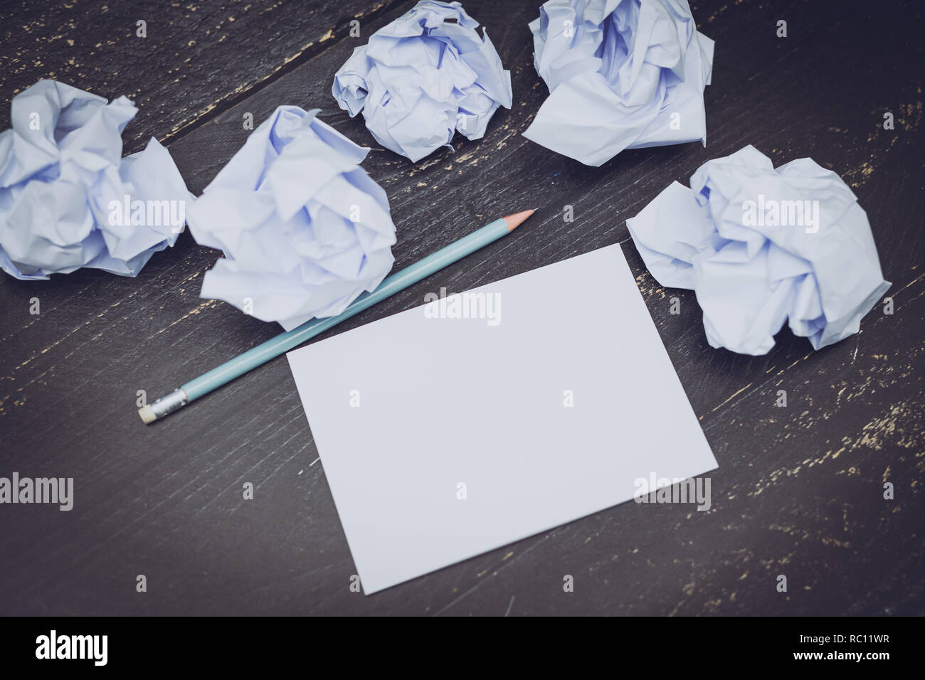 pencil on desk with notepad and scrunched paper balls, concept of drafting and struggling to write documents Stock Photo