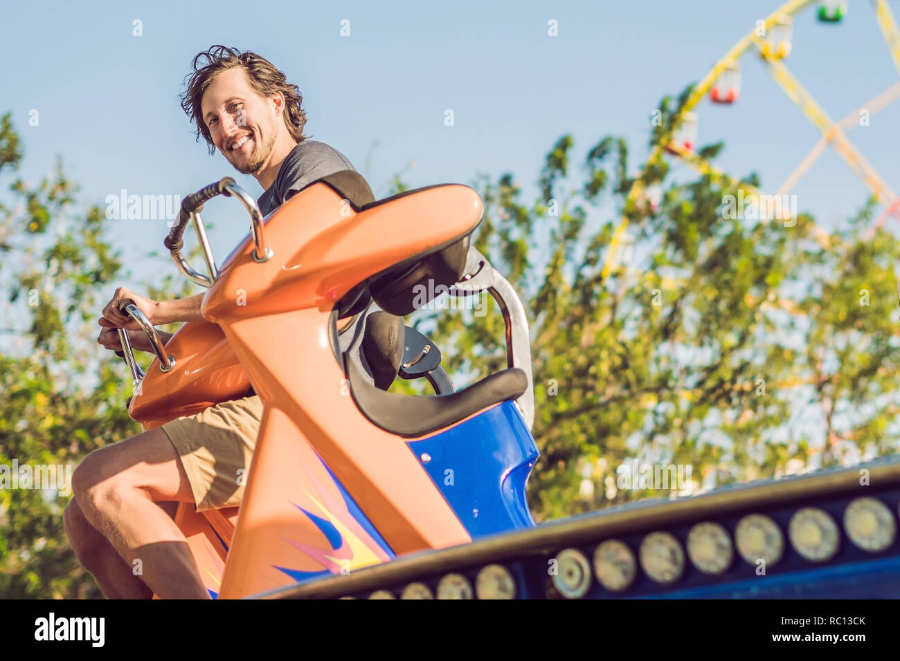 Beautiful, young man having fun at an amusement park Stock Photo - Alamy