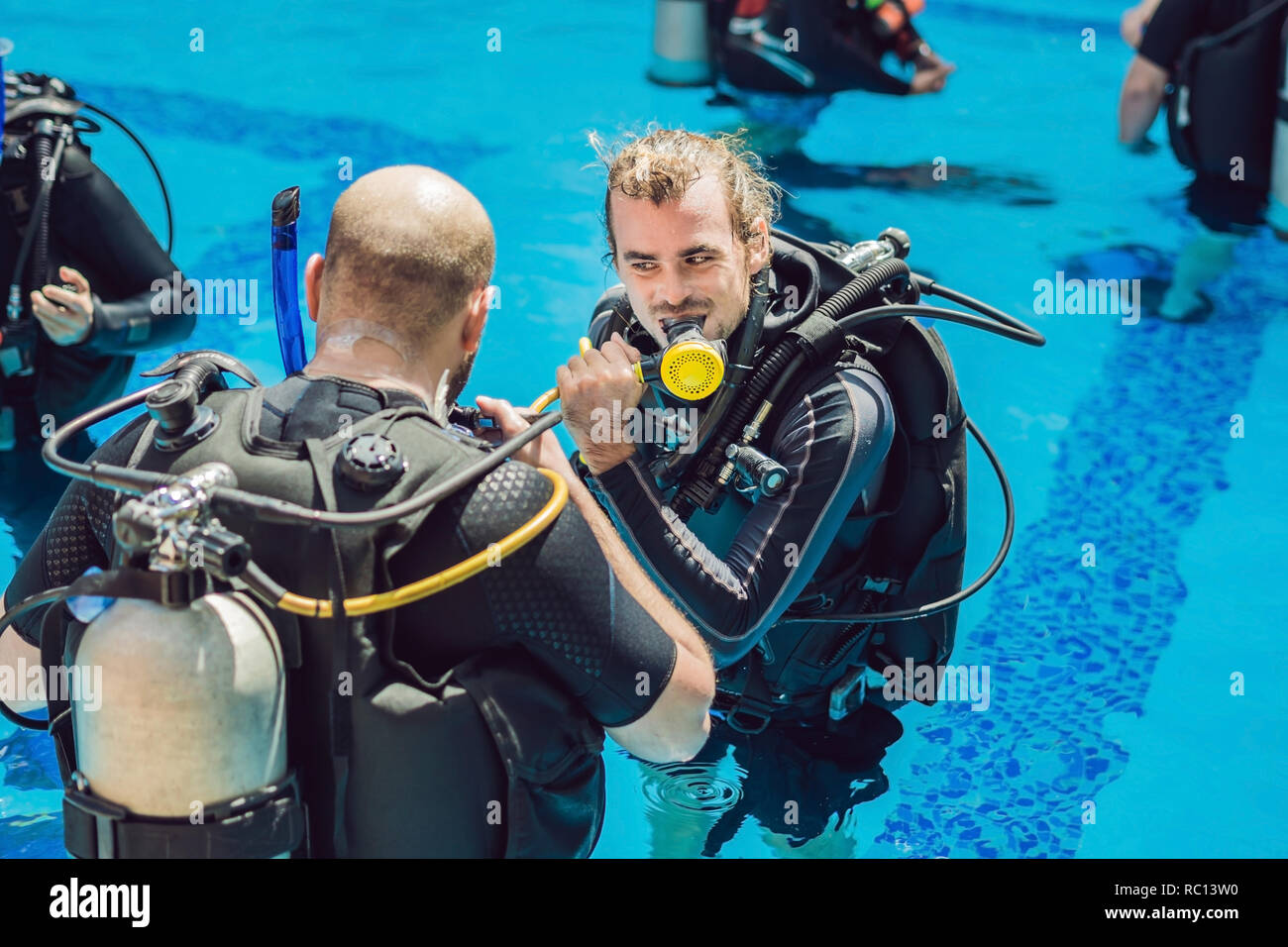 Diving instructor and students. Instructor teaches students to dive