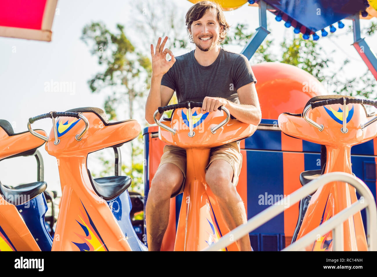 Beautiful, young man having fun at an amusement park Stock Photo - Alamy