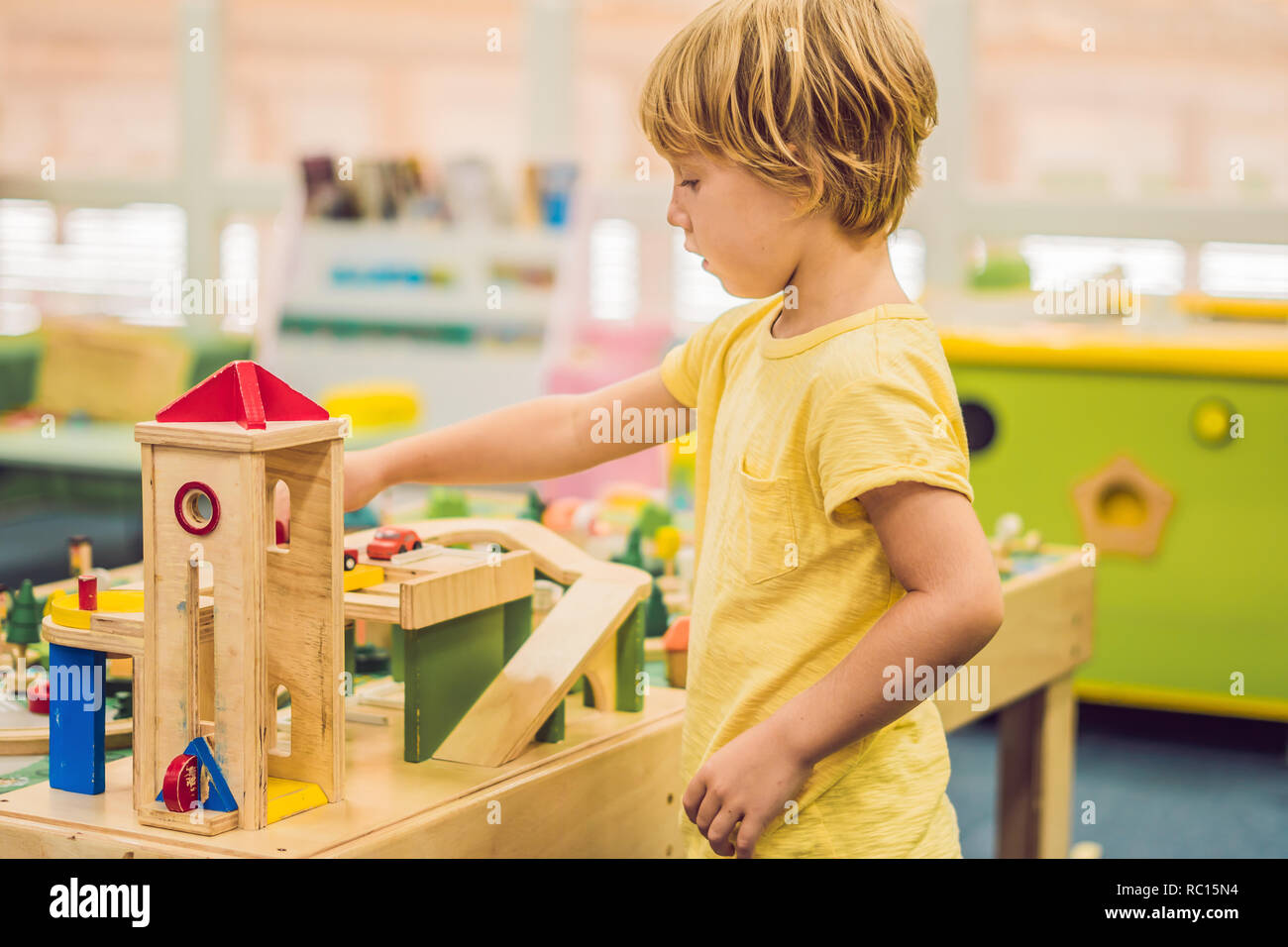 Children play with wooden toy, build toy railroad at home or daycare ...