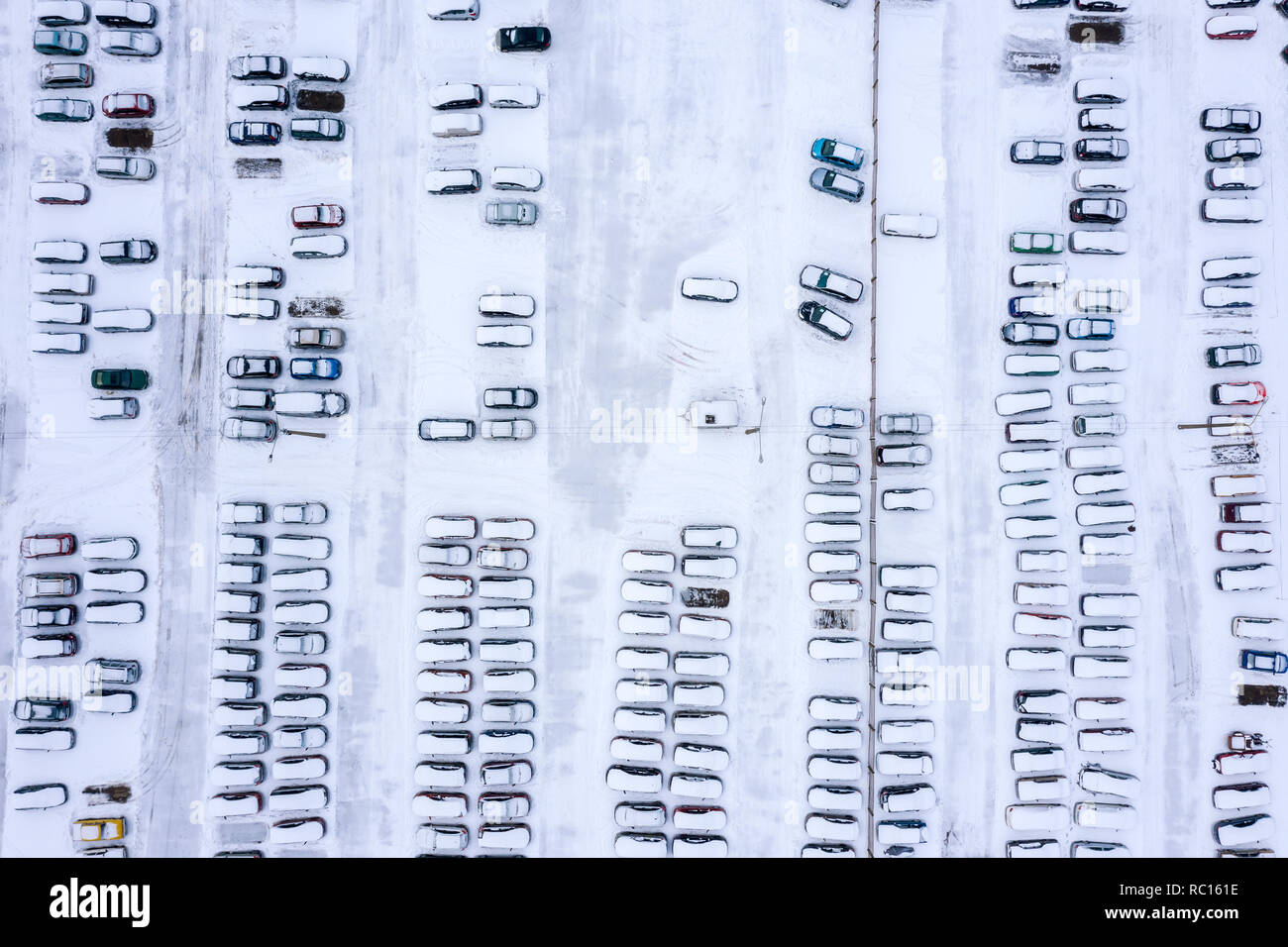 aerial top view of snow-covered cars stand in the parking lot on a ...