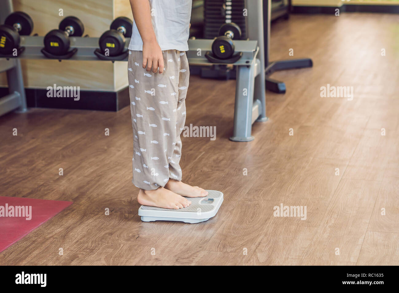 The boy stands on the scales to find out his weight Stock Photo Alamy