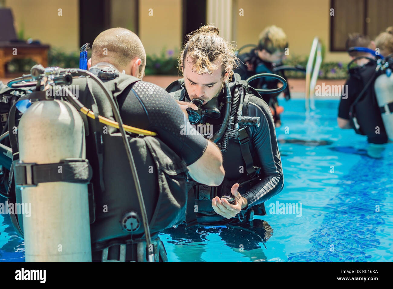 Diving instructor and students. Instructor teaches students to dive