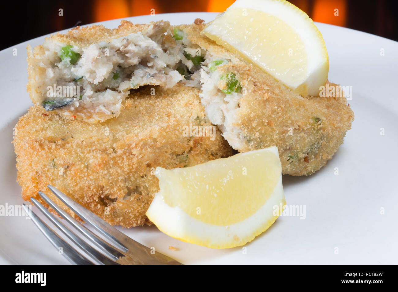 Homemade Breaded Mackerel and pea fishcake with Lemon wedge garnish Stock Photo