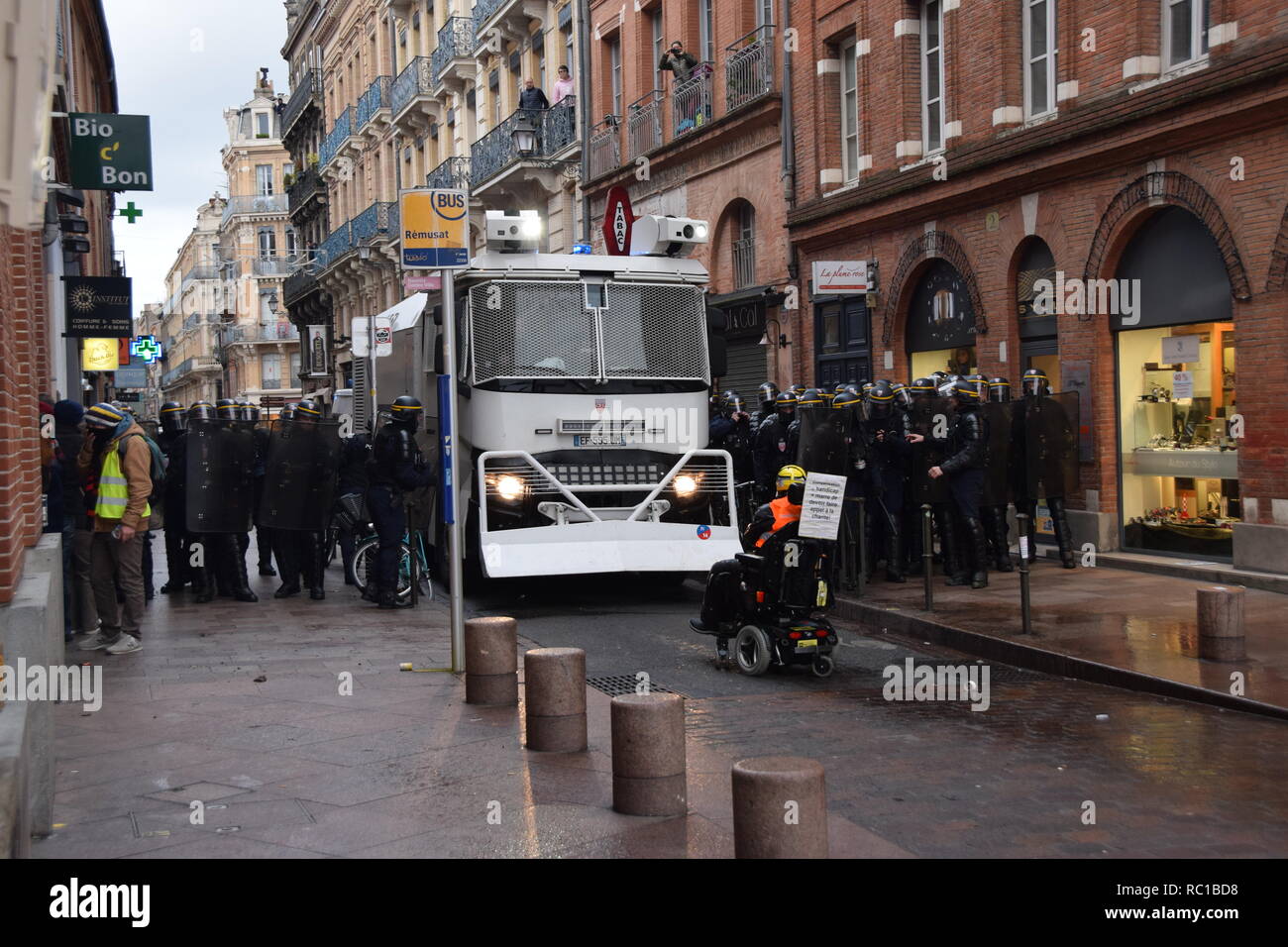 Paris, France. 12th January, 2019. Serious clashes occured on January the 12th in the streets of Toulouse, France, between riot police units and the yellow vest (gilets jaunes). Police largely used tear gas. Such violences occured all over France for act 9. An invalid man on his wheel chair stops a water cannon truck.  Credit: Corentin LE GALL/Alamy Live News Stock Photo