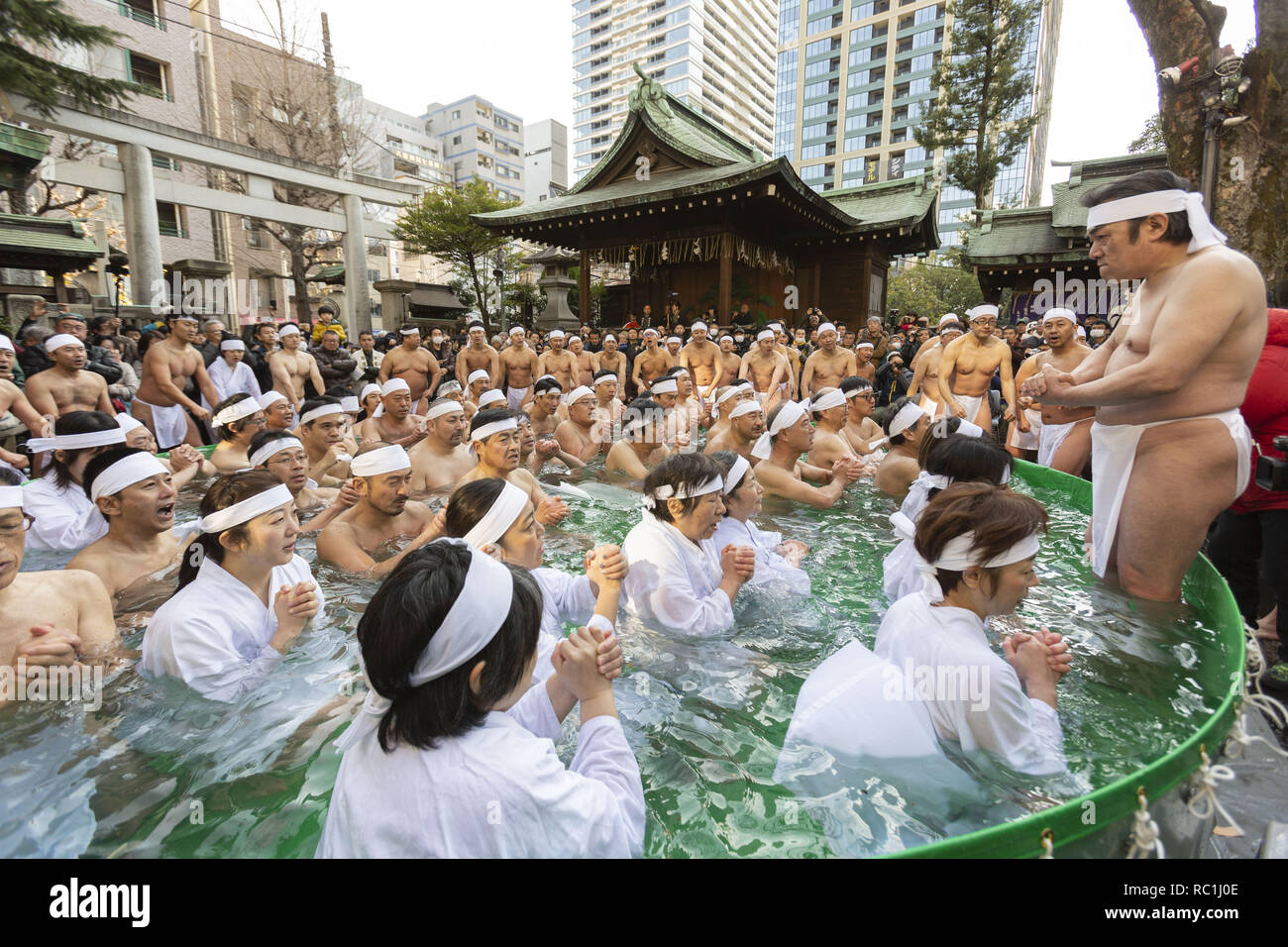 Tokyo, Japan. 13th Jan, 2019. Participants dressed only in loincloths pray in a pool of freezing-cold water containing large blocks of ice during the annual midwinter-ice water bathing (Kanchu-Suiyoku) purification ceremony at Teppozu Inari Shrine. About 91 brave participants (11 women) joined the purification ritual to pray for a healthy new year. Credit: Rodrigo Reyes Marin/ZUMA Wire/Alamy Live News Stock Photo