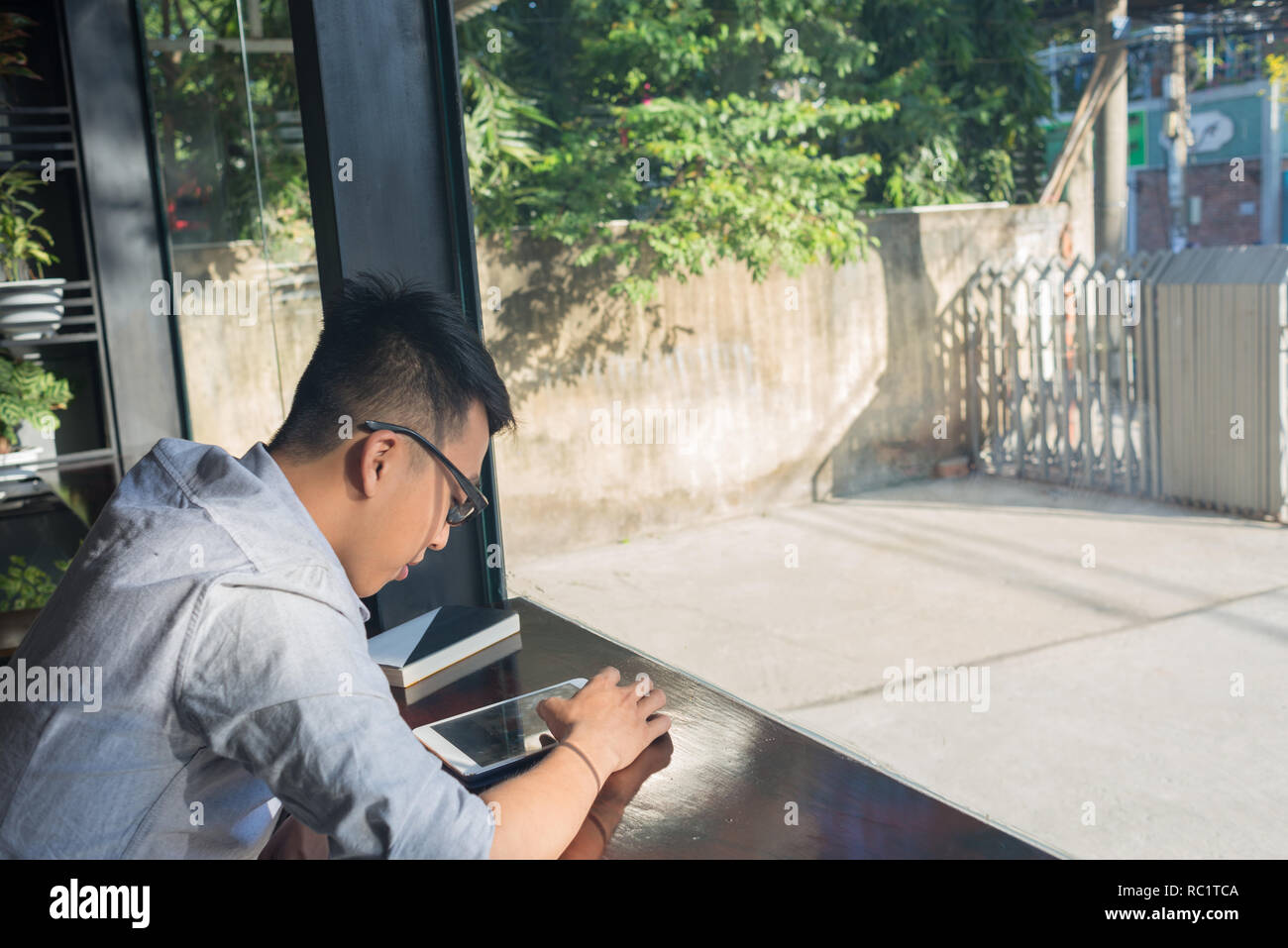 Asian student using tablet to read online newspaper Stock Photo
