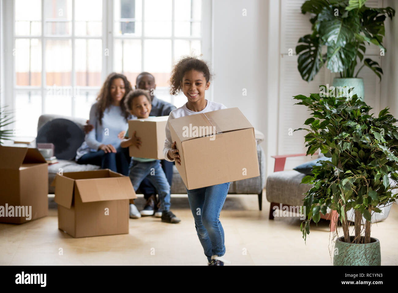 Happy mixed race kids playing with boxes on moving day Stock Photo - Alamy