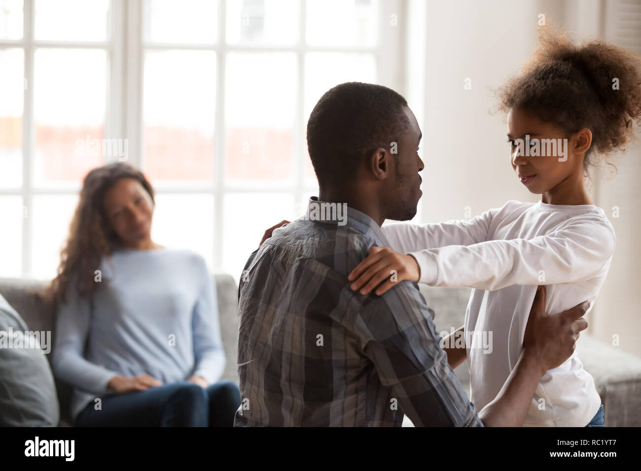 African dad talking to daughter having friendly conversation at  Stock Photo
