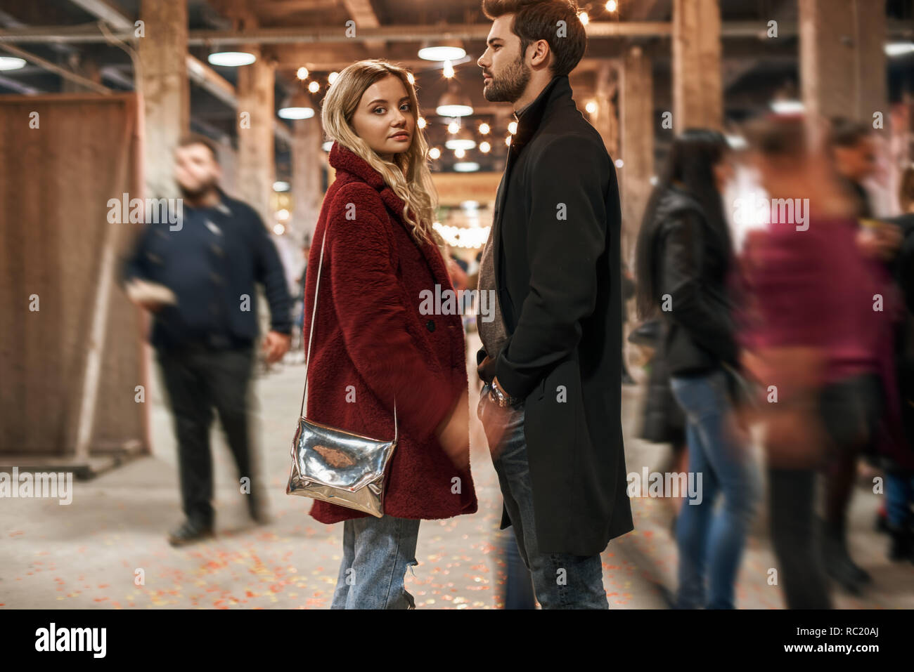 Stroll through the market together. Happy young joyful couple standing in rows at small street market. Autumn season, blond haired woman looking to th Stock Photo
