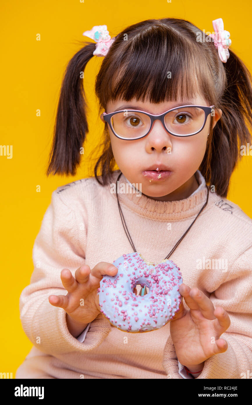 Surprised adorable little child showing fresh donut Stock Photo