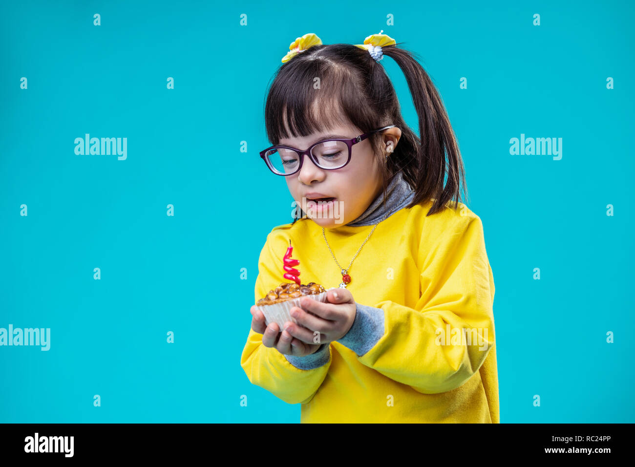 Shorthaired unusual girl with down syndrome carrying cake Stock Photo