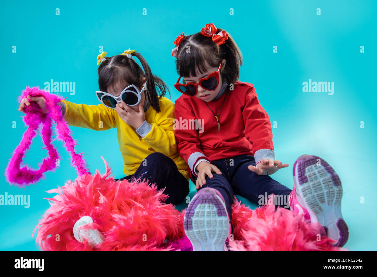 Stylish adorable girls with down syndrome playing with decoration Stock Photo