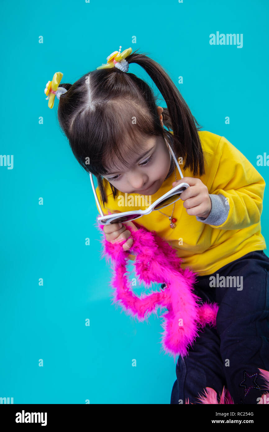 Curious dark-haired little girl with down syndrome Stock Photo