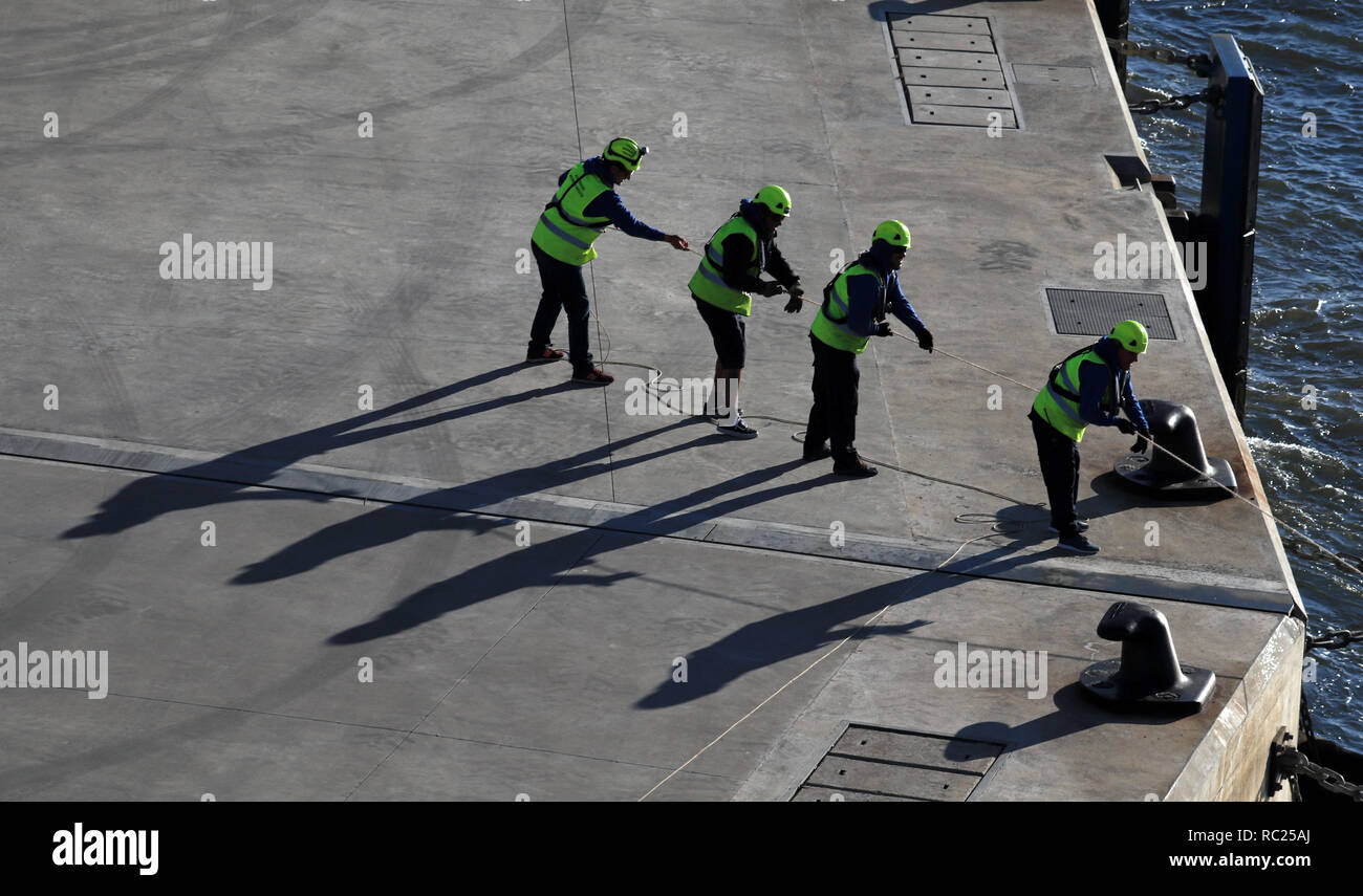 Workers Pulling Ropes Four port workers pulling a mooring rope ashore in Lisbon Four port ...