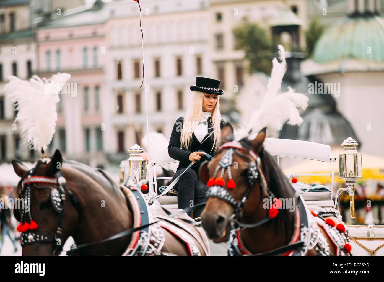 Krakow, Poland - August 28, 2018: Young Beautiful Woman Working Coachman On Old-fashioned Coach Carriage At Main Market Square In Sunny Summer Day. Stock Photo