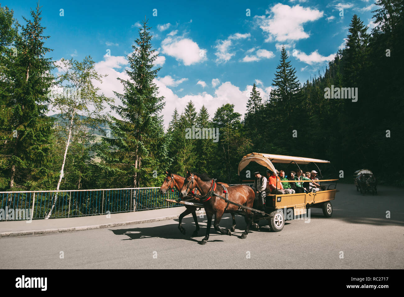 Tatra National Park, Poland - August 29, 2018: Man In National Traditional Polish Folk Ethnic Costumes Ride A Cart Harnessed By A Pair Of Horses Along Stock Photo