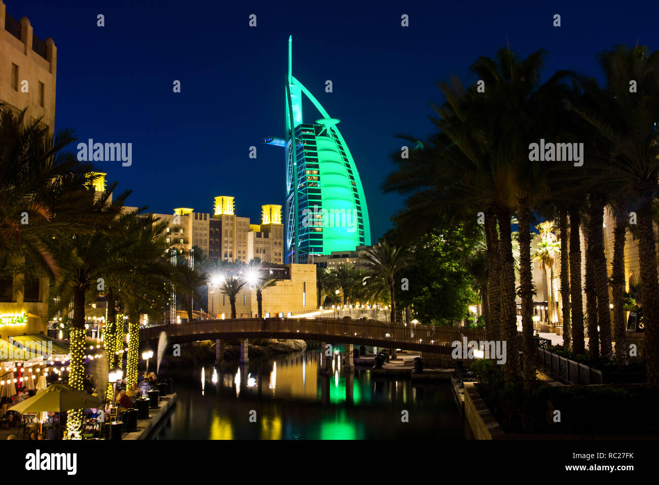 Dubai, United Arab Emirates - April 20, 2018: Burj Al Arab luxury hotel reflected in water at night, view from the Madinat Jumeirah luxury resort in D Stock Photo