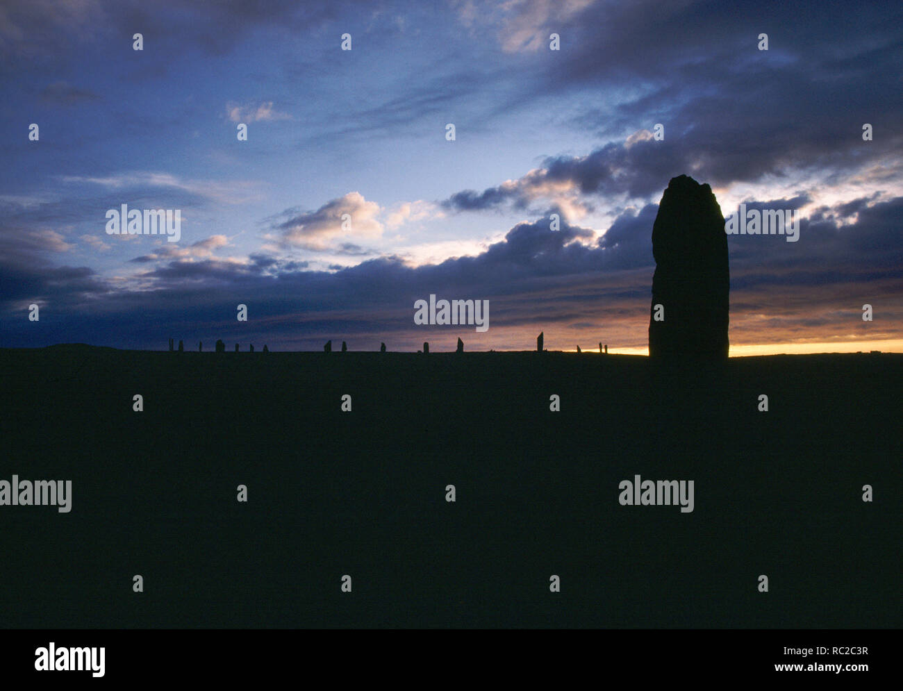 The Comet Stone outlier and Ring of Brodgar prehistoric stone circle & henge, Mainland Orkney, Scotland. Looking north west after sunset. Stock Photo