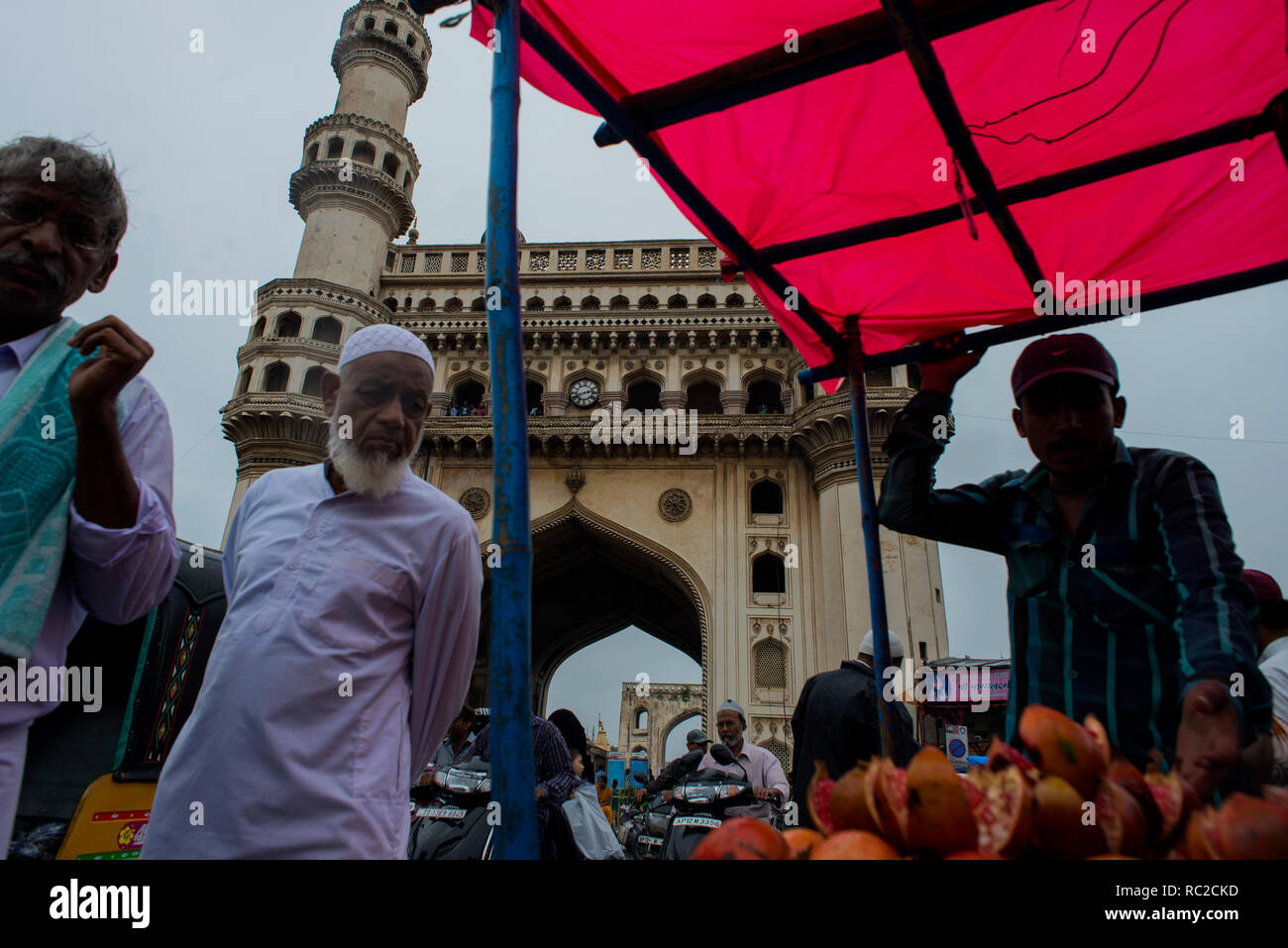 A Muslim man inspects fruits before buying near Charminar in the old quarters of Hyderabad. Stock Photo