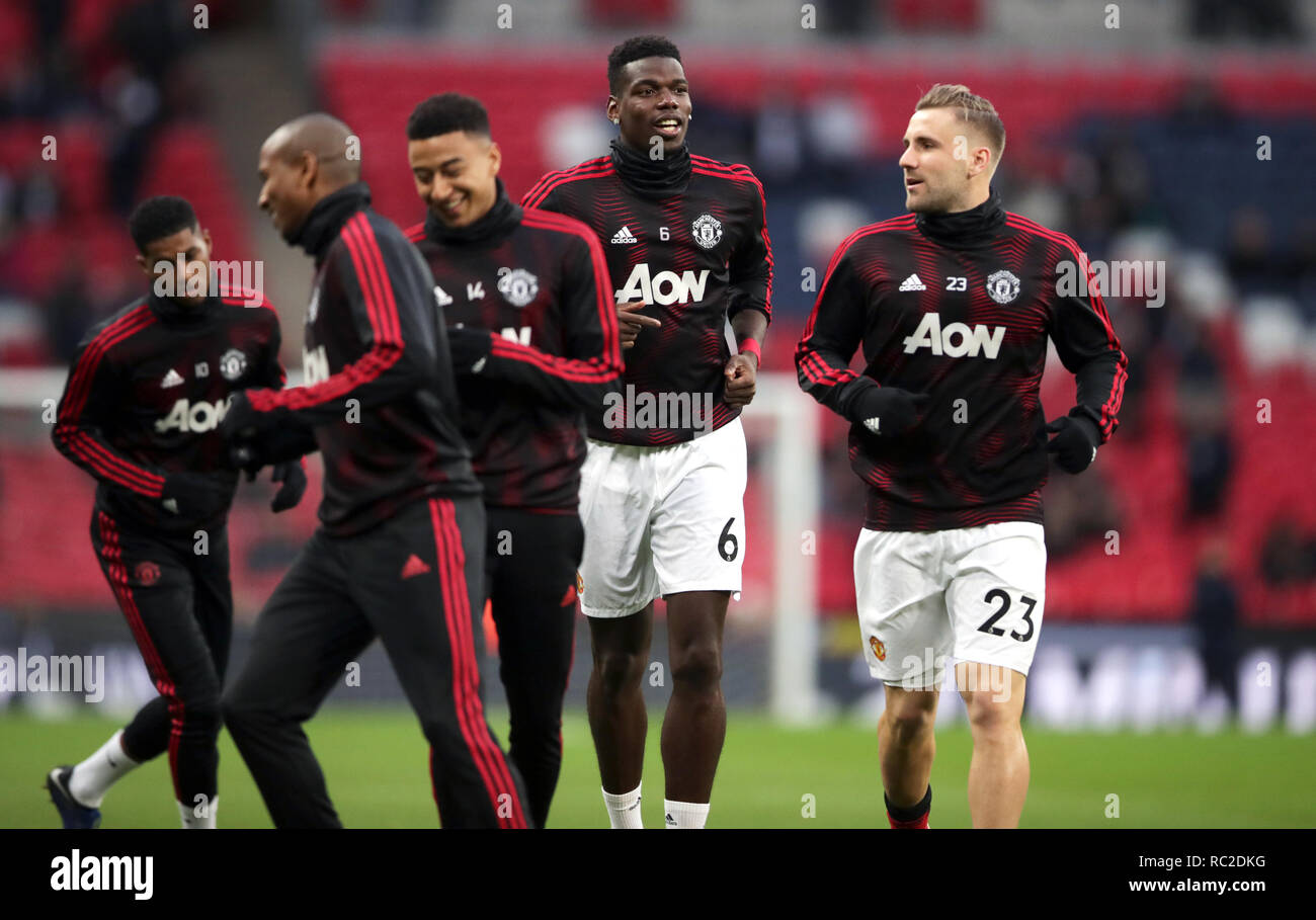 Manchester United's Paul Pogba (centre) and Luke Shaw (right) warm up before the Premier League match at Wembley Stadium, London. Stock Photo