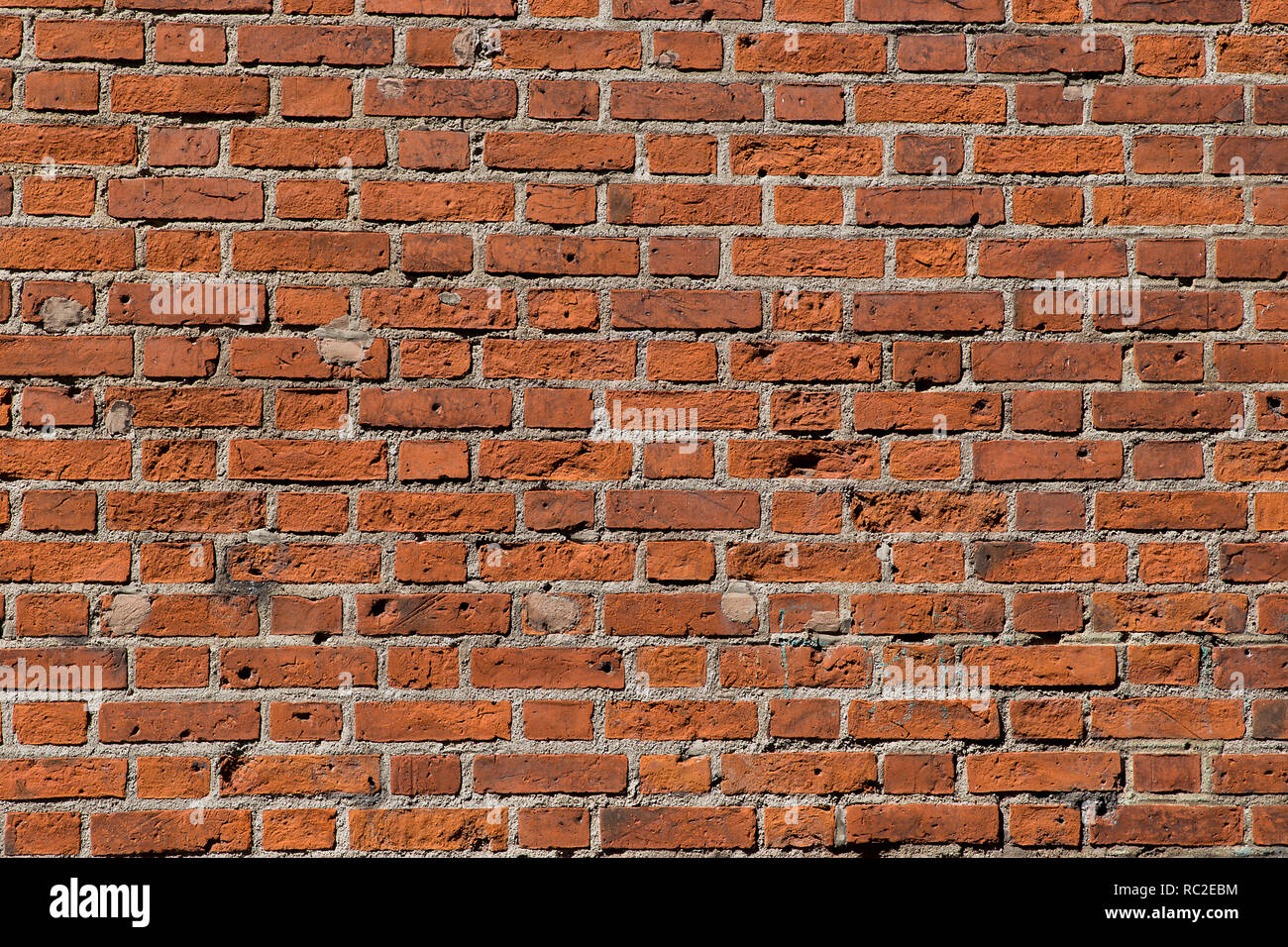 Ancient red brick wall with bullet holes. Stock Photo