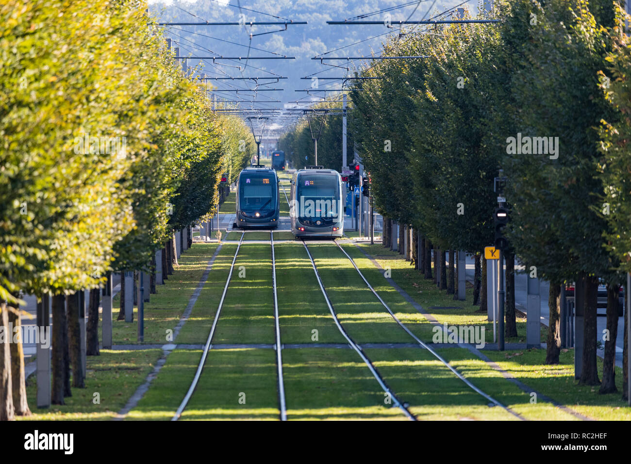 Bordeaux, France - 27th September, 2018: Modern public tranport trams passing through tree lined streets in the city of Bordeaux. Stock Photo