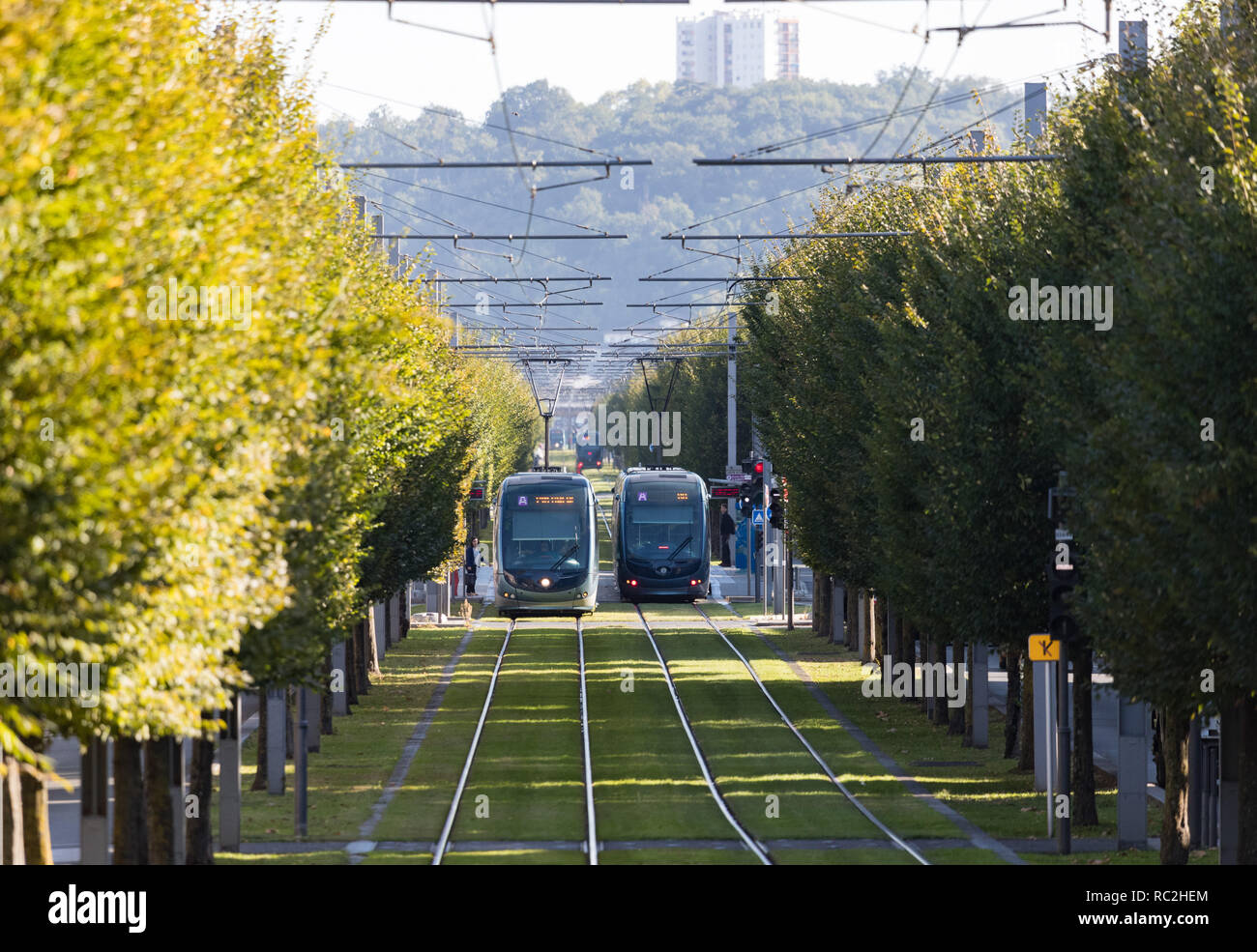 Bordeaux, France - 27th September, 2018: Modern public tranport trams passing through tree lined streets in the city of Bordeaux. Stock Photo